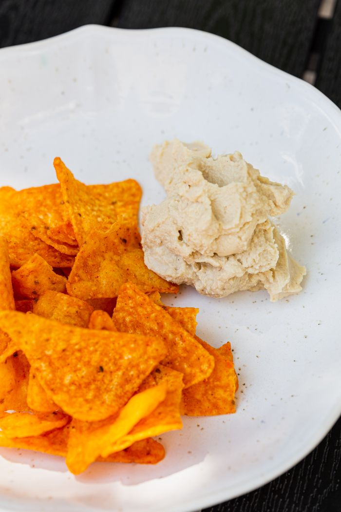 The Art of Drawing Readers In: Your attractive post title goes here A plate of seasoned nacho chips served with creamy hummus, perfect for a healthy snack.